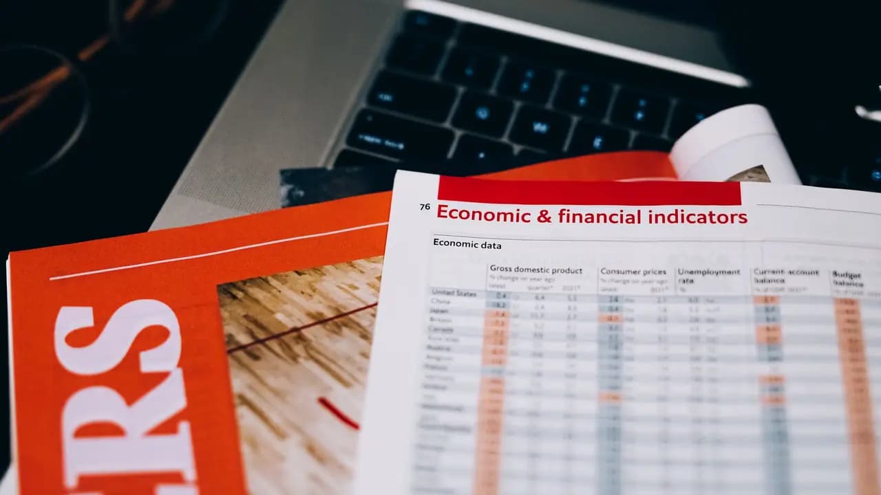 Financial documents and figures beside a laptop keyboard