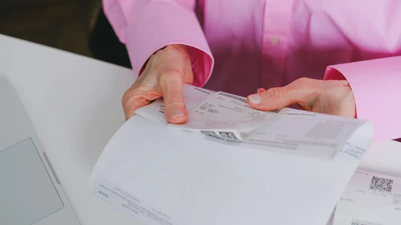 Paper invoices and receipts being sorted by hand