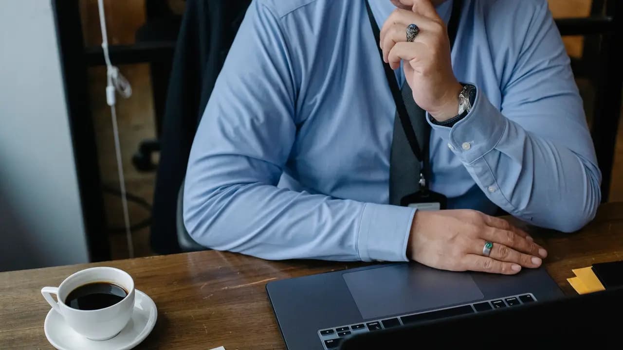 A small business owner pausing at a laptop