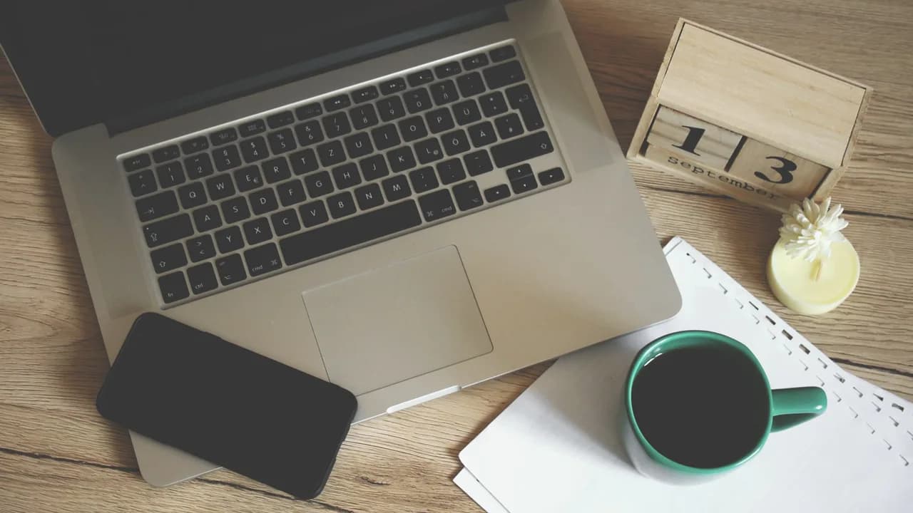 Ein Laptop und eine Tasse Kaffee auf einem Bürotisch